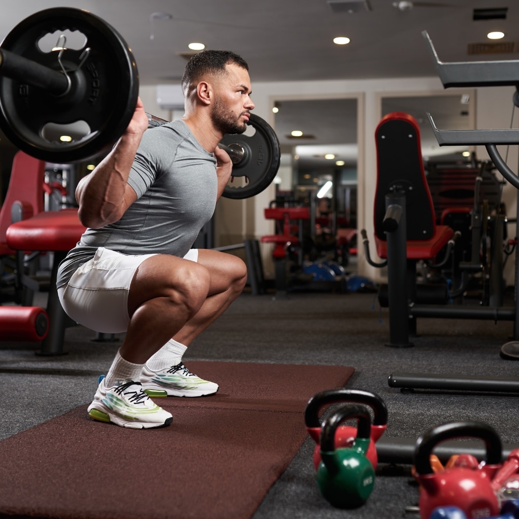 Image of a person performing squat assistance exercises with a trainer