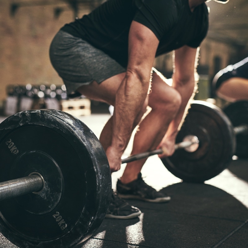 Fit man demonstrating strength and gaining muscle mass in a gym