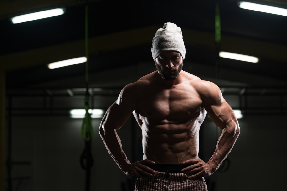 A man flexing his muscles showing the results of building muscle through flexing exercises