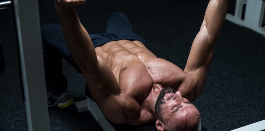 Man performing chest and triceps workouts using gym equipment for strength training